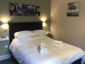 ein Schlafzimmer mit einem Bett mit Handtüchern darauf in der Unterkunft Plum Pudding in Abingdon