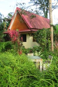 a house with a red roof in the forest at Manora Garden in Phangnga