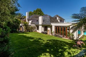a house with a yard with green grass at Fernwood Manor Boutique Guest House in Cape Town