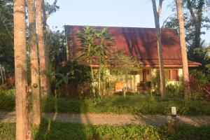 een huis in de jungle met een rood dak bij Manora Garden in Phangnga