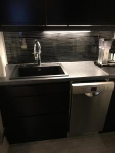 a kitchen with a sink and a dishwasher at Viihtyisä asunto keskustassa palvelujen lähellä in Heinola