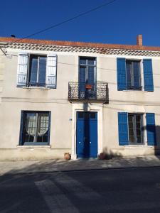 Casa blanca con puertas y ventanas azules en La Vicoise Accueillante en Vic-Fezensac