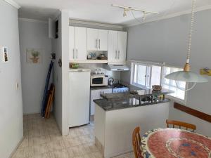 een keuken met witte kasten en een aanrecht bij ED. EL ARANZAL in Punta del Este