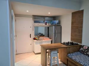 una cucina con frigorifero, tavolo e bancone di Apartamento na Av Atlantica com Ar Condicionado a Balneário Camboriú