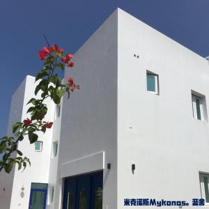 un edificio blanco con flores rojas. en Blue House, en Jincheng