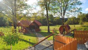 a yard with a wooden fence and a cabin at Zakątek nad Wiarem in Wojtkowa