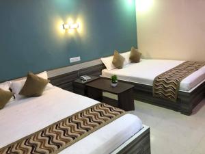 ein Hotelzimmer mit 2 Betten und einem Tisch in der Unterkunft Yara Hotel in Itahari