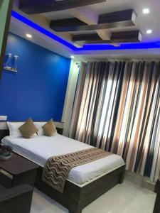 łóżko w pokoju z niebieską ścianą w obiekcie Yara Hotel w mieście Itahari