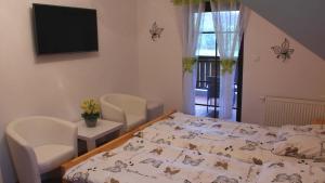 una camera con letto, sedie e TV di Zakątek nad Wiarem a Wojtkowa