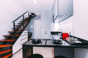 una cucina con bancone nero e scala di Multihouse - Moderno Duplex Berrini - WTC - Brooklin a San Paolo