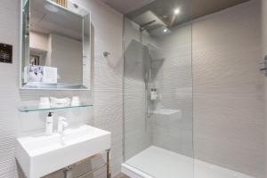 a bathroom with a shower, sink, and mirror at Murrayfield Hotel in Edinburgh