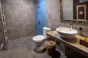 a bathroom with a sink and a toilet and a mirror at PNB Bali Villas in Canggu