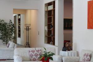 アーバノ・テルメにあるテルメ ヴィラ ペースのリビングルーム(白いソファ2台、鏡付)