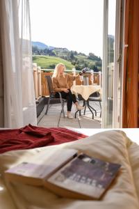 une femme assise sur une chaise à une table dans une pièce dans l'établissement Hotel Garni Erlbacher, à Schladming