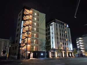 京都市にあるグリーンリッチホテル京都駅南（人工温泉 二股湯の華）の夜間照明付きの高層ビル