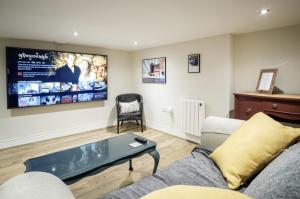 a living room with a couch and a tv at 107 Nunnery Lane - a House of York holiday home in York