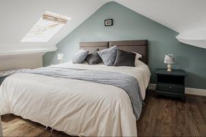 107 Nunnery Lane - a House of York holiday home في يورك: غرفة نوم بسرير كبير بجدار ازرق