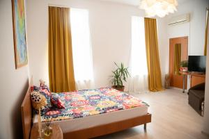 1 dormitorio con 1 cama con colcha colorida en Pensiunea Lms, en Brăila