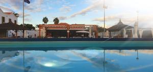 a swimming pool in front of a building at FBC Fortuny Resort - Adults Only in Maspalomas