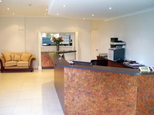 a hotel lobby with a reception desk and a chair at Mackellar Motel in Gunnedah