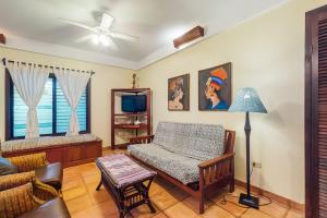 a living room with a bed and a tv at Beachside Villas Gold Standard Certified in Placencia Village