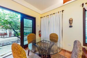 ein Esszimmer mit einem Glastisch und Stühlen in der Unterkunft Beachside Villas Gold Standard Certified in Placencia Village