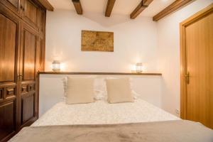 una camera da letto con un letto con due cuscini di La Casa de Jabe - Toledo Casco Antiguo a Toledo