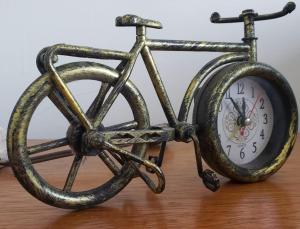 a metal bike with a clock sitting on a table at Suites Villa Forte Santana in Florianópolis