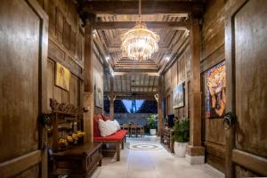 a hallway with a chandelier and a red couch at PNB Bali Villas in Canggu