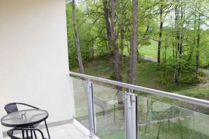 balkon ze stołem i widokiem na las w obiekcie Apartament - studio Wisła z widokiem na góry w Wiśle