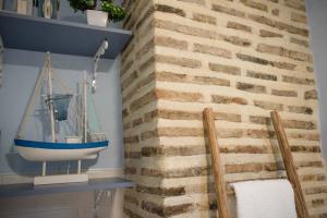 トレドにあるLa Casa de Jabe - Toledo Casco Antiguoのレンガの壁のバスルーム(ボート付)