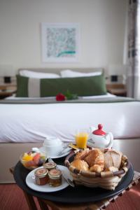 Hotel La Manufacture في باريس: صينية طعام الإفطار على طاولة بجوار سرير