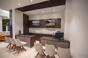 an office with a reception desk with white chairs at Mitru Express Hotel in La Paz