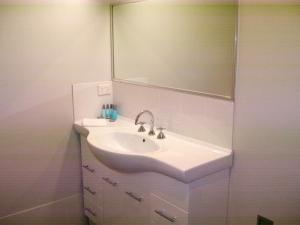 a white sink sitting under a mirror in a bathroom at Mackellar Motel in Gunnedah