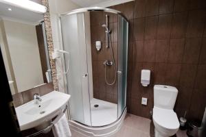 een badkamer met een douche, een toilet en een wastafel bij Optima Collection Troitska in Dnipro