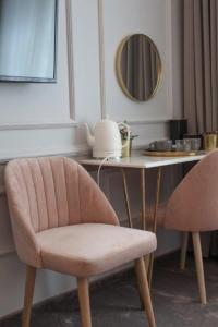 - un bureau avec une chaise rose et un miroir dans l'établissement Boleslav Home De Luxe, à Sucha Beskidzka