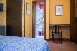 um quarto com uma cama e uma cadeira num quarto em Gaia B&B em Castrovillari