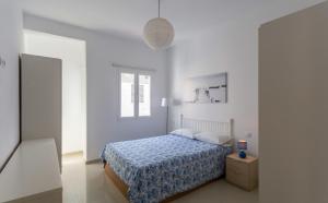ラスパルマス・デ・グランカナリアにあるBright with terrace next to the beachの白いベッドルーム(ベッド1台、窓付)