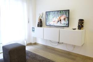 a living room with a tv on a white wall at Porto River Sunset 1st in Vila Nova de Gaia