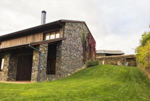 ein Steinhaus mit einem grasbewachsenen Hügel daneben in der Unterkunft Casa de campo en Nahuja in Nahuja