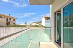 コスタ・ノヴァにあるCasa da Praia Costa Novaのガラス張りのバルコニーから建物の景色を望めます。