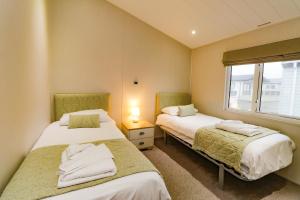 ペバンゼイにある3 bedroom Lodge at Pevensey Bayの窓付きの小さな部屋のベッド2台