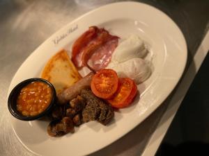 a plate of food with eggs bacon tomatoes and beans at The Gables Hotel in Gretna Green