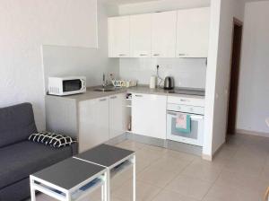 a small kitchen with a couch and a microwave at Apartamento tranquilo Sun Beach in Caleta De Fuste