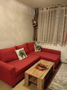 1 sofá rojo en la sala de estar con mesa de centro en Апартамент в апарт хотел Forest Nook- Пампорово, en Pamporovo