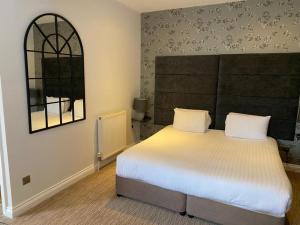a bedroom with a large bed and a large window at The Mount Hotel Country Manor Wolverhampton in Wolverhampton