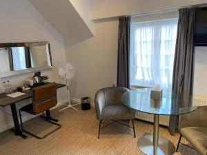 a living room with a glass table and a chair at The Mount Country Manor Hotel & Golf Wolverhampton in Wolverhampton