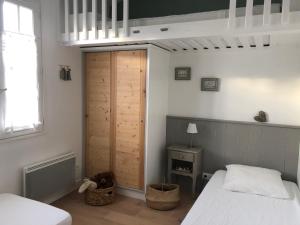 a bedroom with a bed and a wooden door at Villa Pigouille in Sainte-Marie-de-Ré