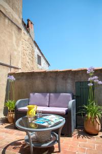 a patio with a table and a couch at La Maison du Prince in Grimaud