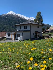 une maison avec un champ de fleurs devant elle dans l'établissement Appartement Klein Tirol, à Pettneu am Arlberg